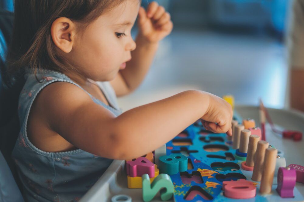 A young girl plays with educational toys.
