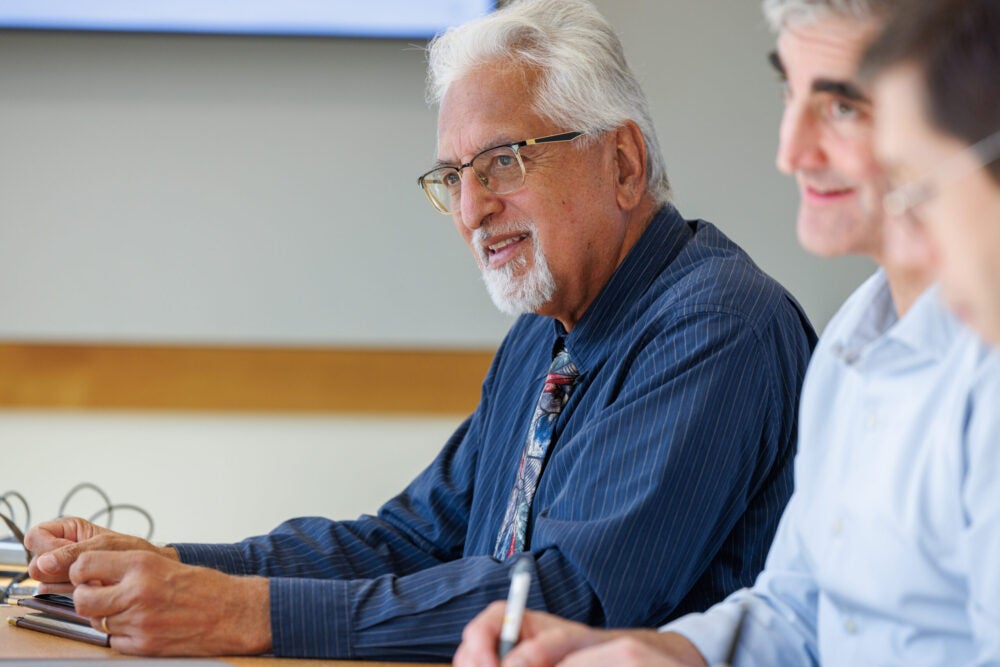 Man sits at a meeting table with other leaders
