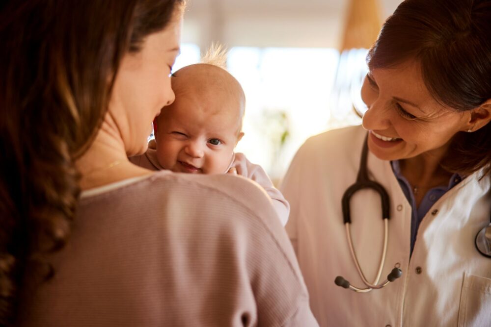 A nurse talks with a mom holding a baby.